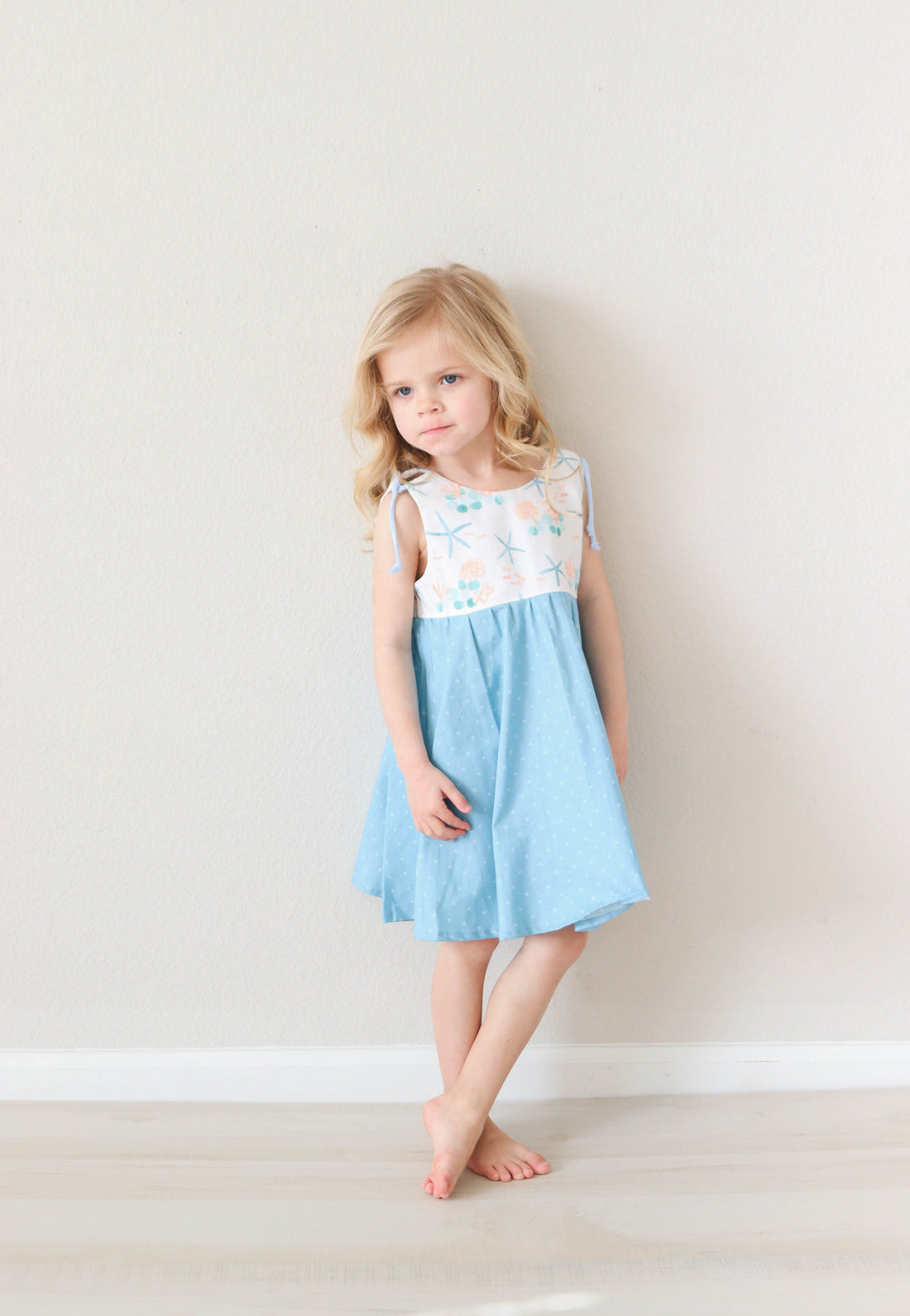Girl wearing the blue starfish dress by bitty bambu