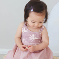 Girl wearing the 'Bird of Paradise' dress, showcasing the full skirt and sitting on a chair
