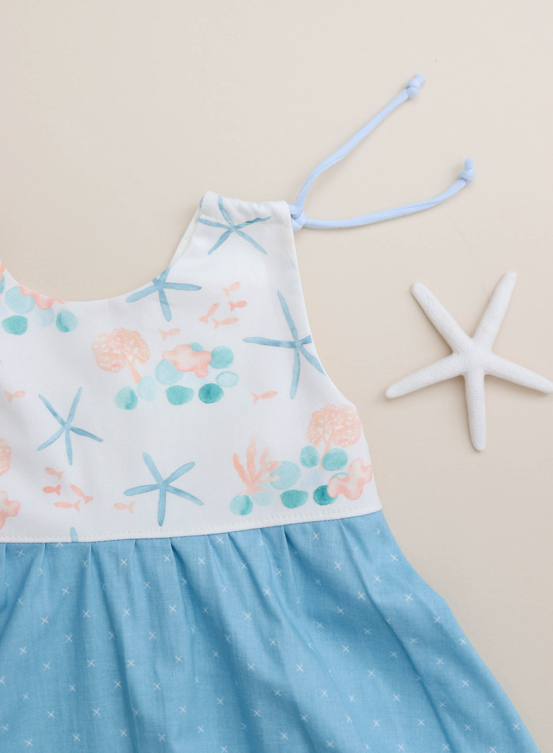 Close-up of adjustable shoulder straps on the blue starfish dress.
