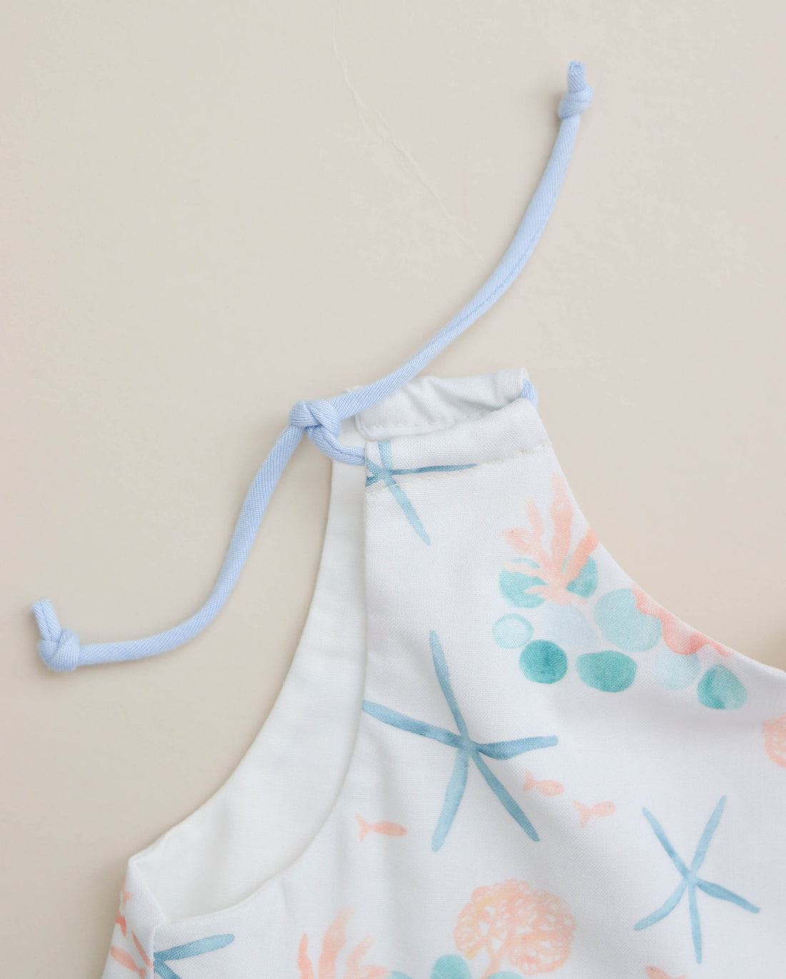 Close-up of adjustable shoulder straps on the blue starfish dress.