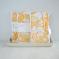 Yellow burp cloths with an octopus pattern, displayed on a neutral background.