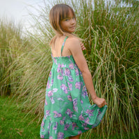 Handmade girls dress in Green Bougainvillea print with adjustable tie shoulder straps and ruffled hem, made out of 100% cotton