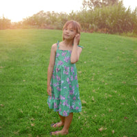 Handmade girls dress in Green Bougainvillea print with adjustable tie shoulder straps and ruffled hem, made out of 100% cotton
