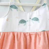 Detail close up of turtle design which showns turtles swimming towards each other in a watercolor style print