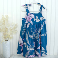 Handmade twirly dress hanging, displaying the full skirt and floral pattern
