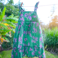 Handmade girls dress in Green Bougainvillea print with adjustable tie shoulder straps and ruffled hem, made out of 100% cotton