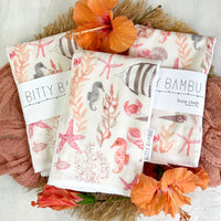 Details of the coordinating burp cloth with a ocean theme watercolor design featuring seashores, fish, sea kelp, coral, starfish, crabs and shells