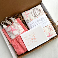 Handmade baby girl gift box featuring an ocean-themed dress and coordinating burp cloth, beautifully packaged and ready for gifting
