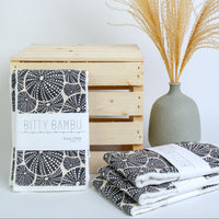 Bitty Bambu towels with a wooden crate and vase on a light background