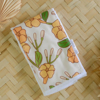 handmade puakenikeni flower baby burp cloth with green leaves and yellow flowers, ideal for newborns and baby gifts by bitty bambu