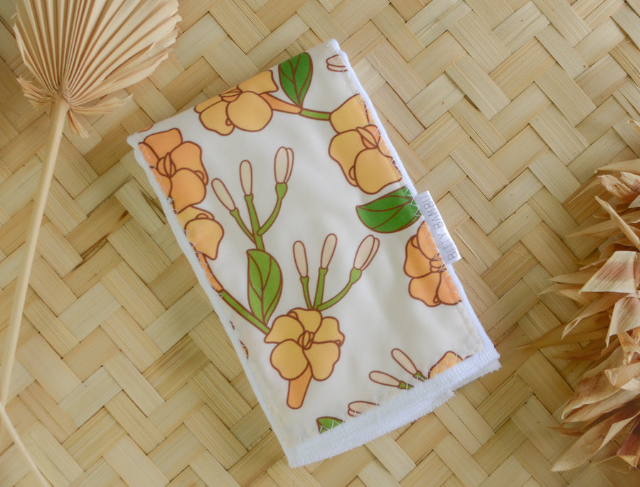 handmade puakenikeni flower baby burp cloth with green leaves and yellow flowers, ideal for newborns and baby gifts by bitty bambu