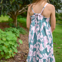 Girl wearing the 'Jade Pua' dress, showcasing the adjustable straps and ruffled hem.