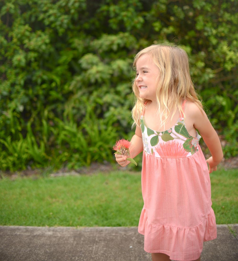 Girl wearing the Ohia Flower dress, displaying the vibrant native Hawaiian flower print and comfortable fit
