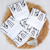 Bitty Bambu burp cloths on a textured surface