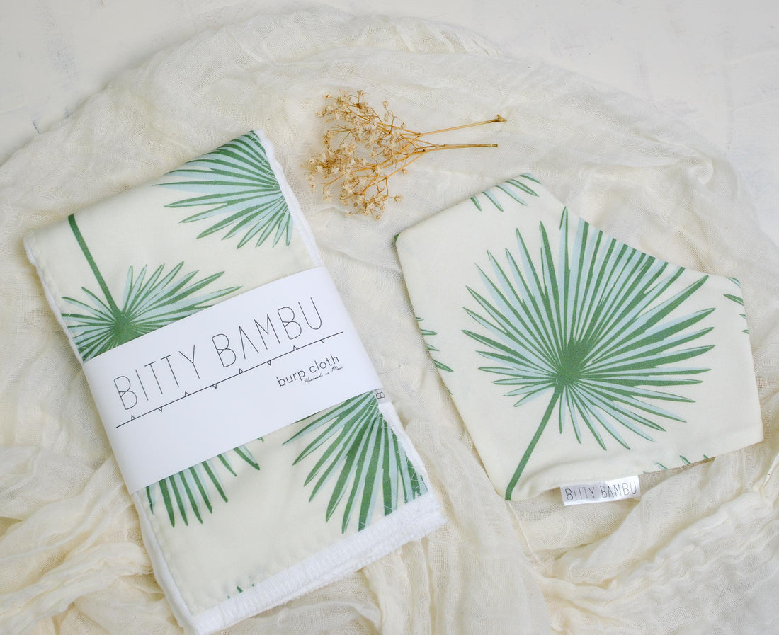 Two baby blankets with palm leaf pattern and 'Bitty Bambu' branding on a soft white background.