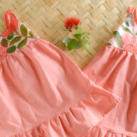 Two Ohia Flower dresses layed flat highlighting the fully lined bodice and floral pattern and ruffled skirt
