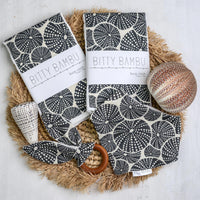 Bitty Bambu products including cloths and a ball on a textured surface